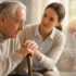 Parkinson Disease elderly patient receiving care and support from caregiver with walking stick indoors